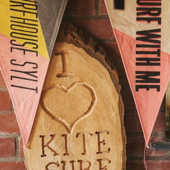 Ein Schild im Surfhouse Sylt, das die Leidenschaft für das Kitesurfen auf der Insel symbolisiert.