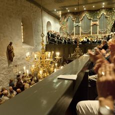 Kirchenkonzert mit Orgel, Chor und Publikum, das begeistert applaudiert.