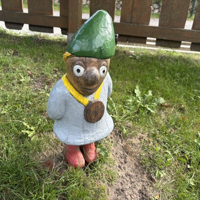 Holzfigur Puk mit Medaille, grünem Hut und roten Stiefeln