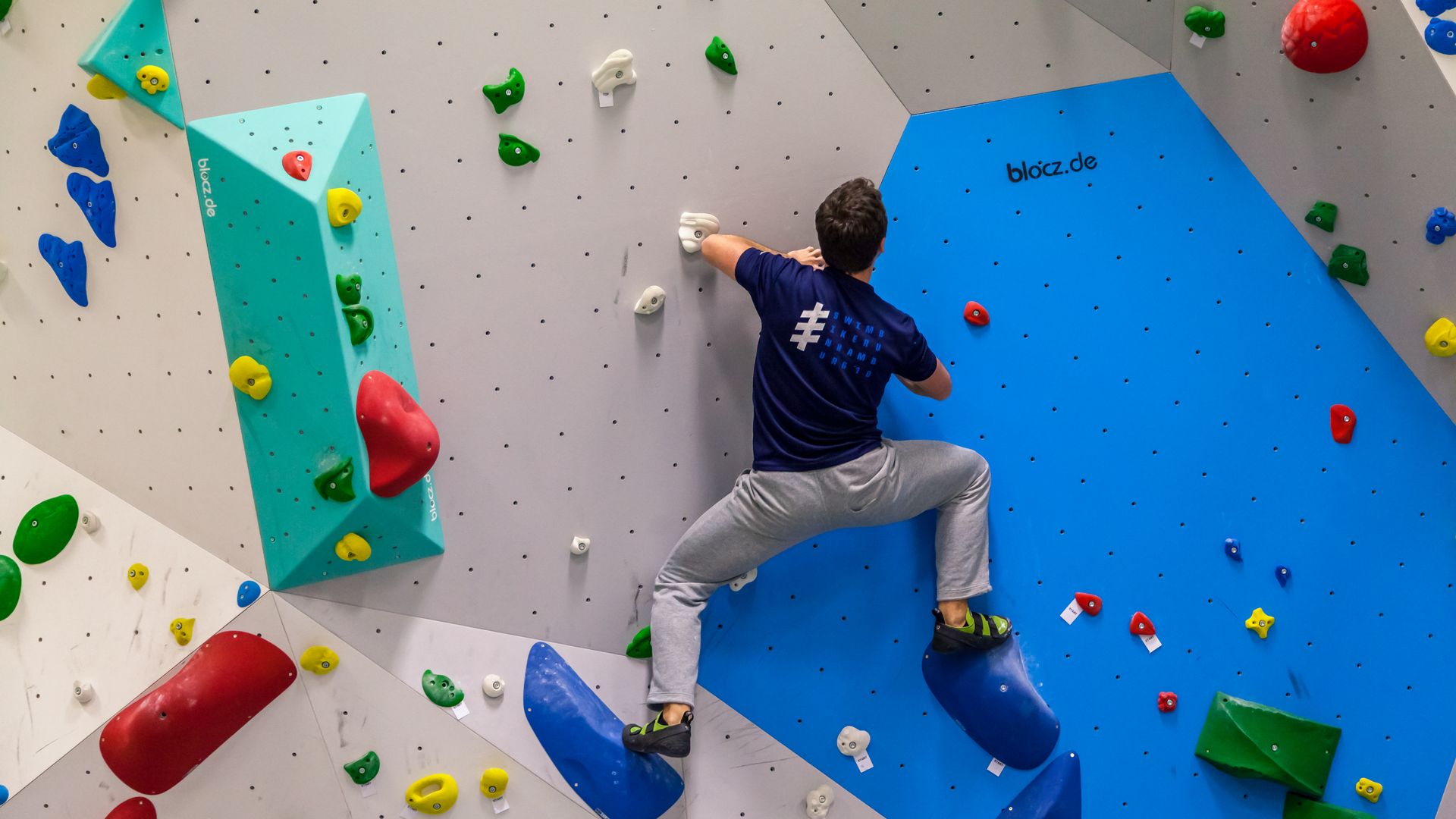 Mann klettert an Boulder Wand