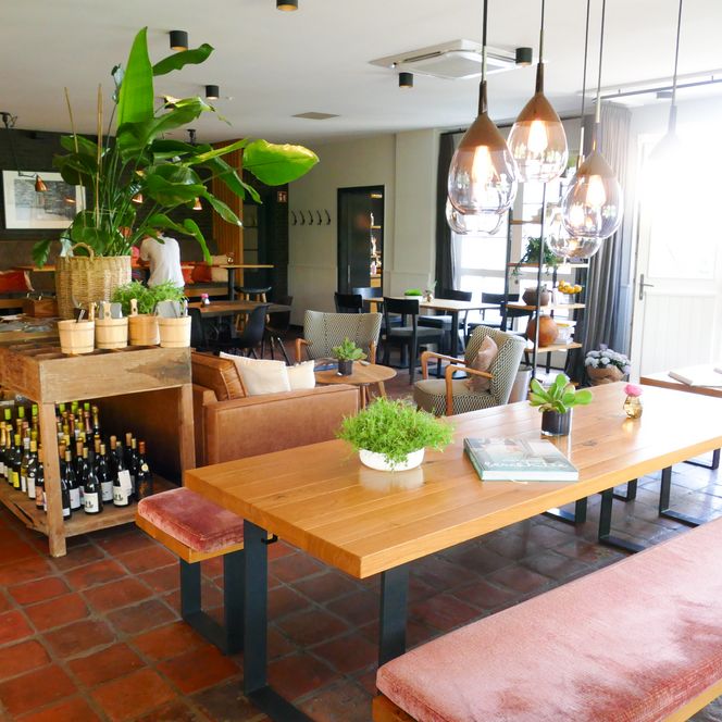 Modern eingerichtetes Restaurant mit Pflanzen, Holz und Lederbänken