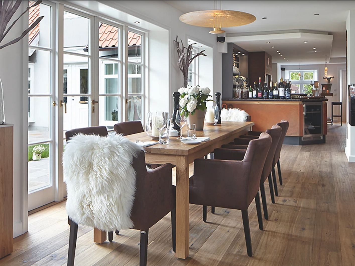 Heller Gastraum mit langem Holztisch