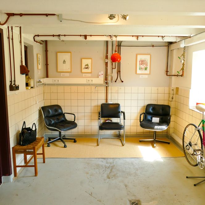 Stühle und Kunst in einem gefliesten Raum mit Galeriecharakter