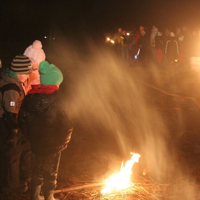 ein paar Kinder stehen um ein kleines Feuer - im Hintergrund die große Biike