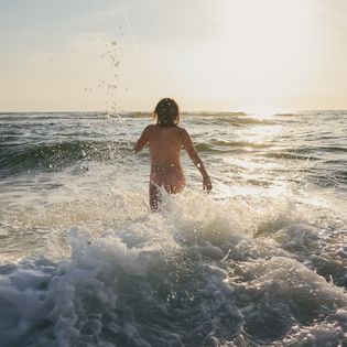 Frau genießt das erfrischende Bad in der Abendsonne