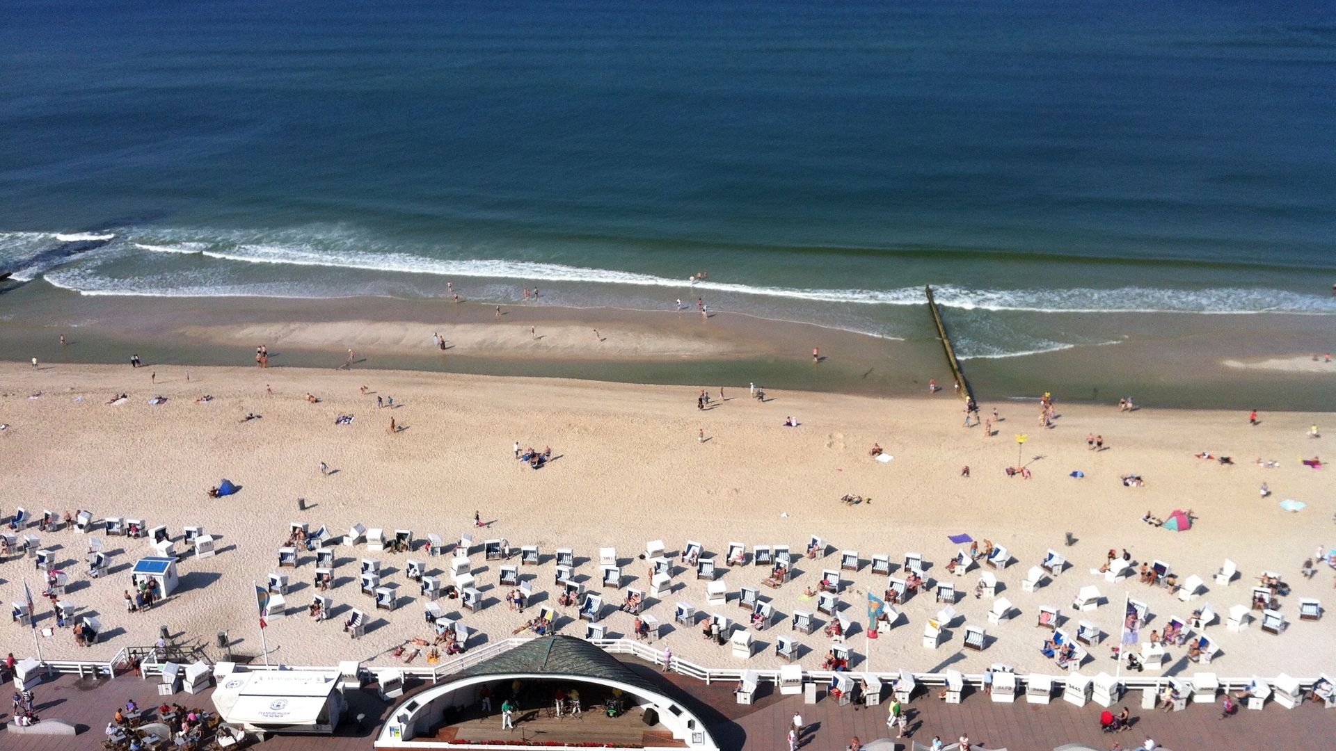 Luftaufnahme der Westerländer Promenade mit der Musikmuschel, dem Strand und den vielen weißen Strandkörben