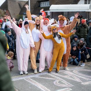 Gruppe in Hasenkostümen beim Ostereierlauf in Kampen, lachend am Startpunkt