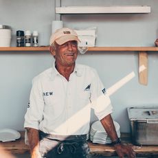 Lachender Mann mit Basecap in einer hellen Küche