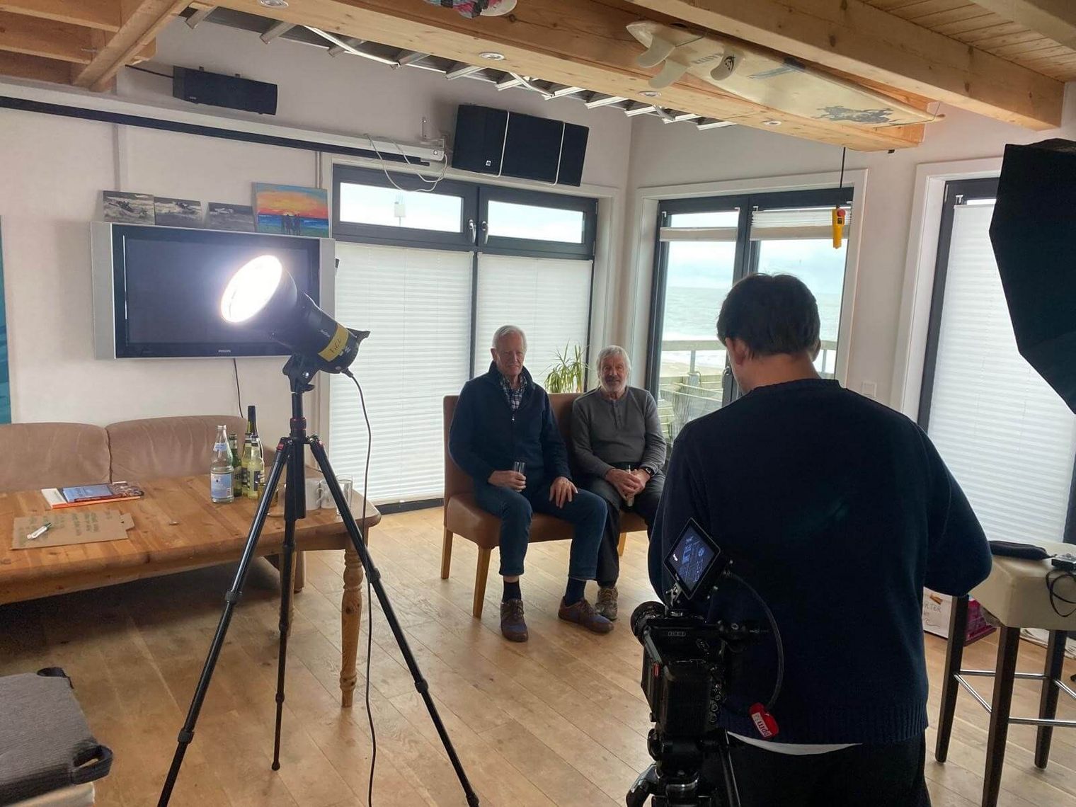 Interview-Dreh mit zwei älteren Männern, Kamera- und Lichttechnik im Raum