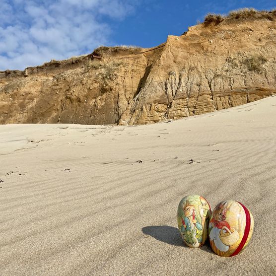 Zwei bemalte Ostereier im Sand vor dem Roten Kliff auf Sylt