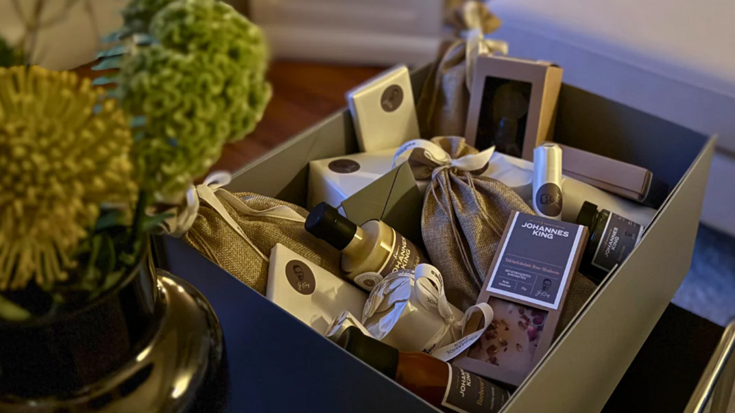 Geschenkbox mit Feinkost, dekorativ verpackt in einem gemütlichen Raum.