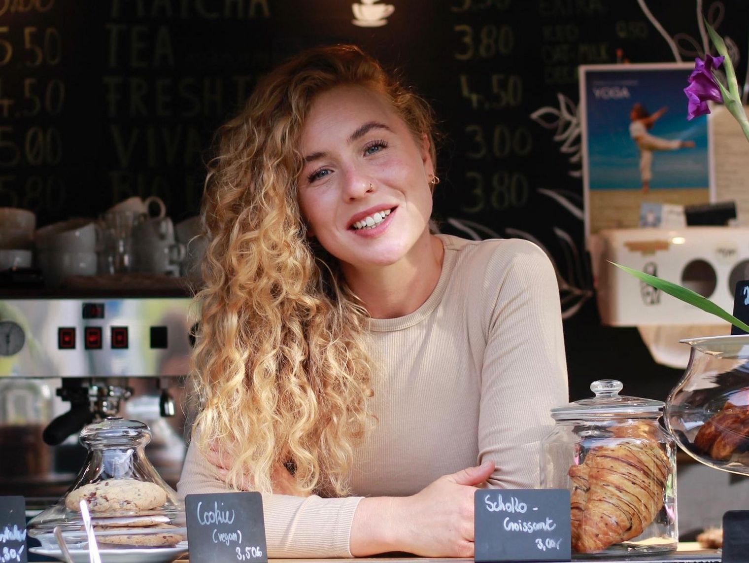 Jarla Hader lächelt hinter der Theke ihres sandgelben Kaffeewagens.