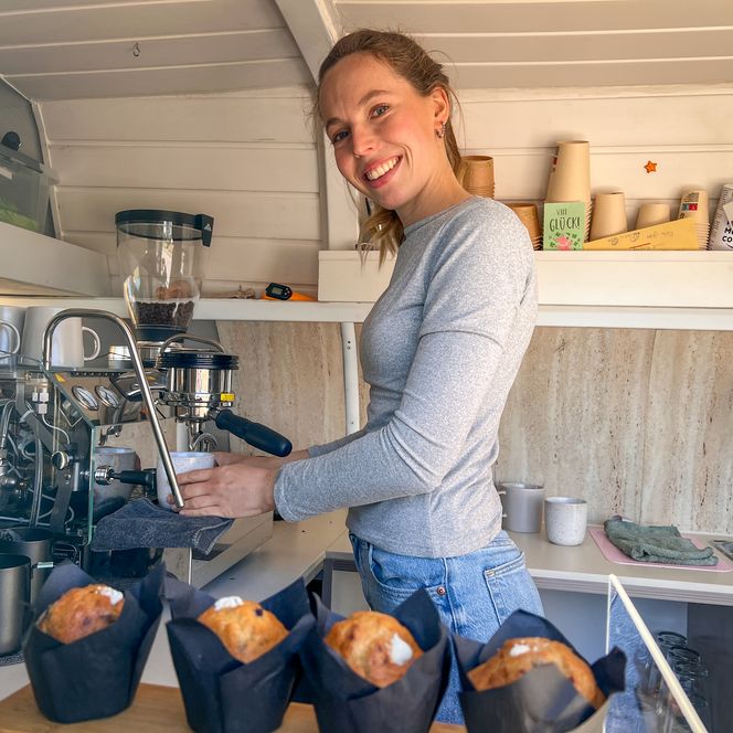 Junge Frau bereitet Kaffee an der Siebträgermaschine zu