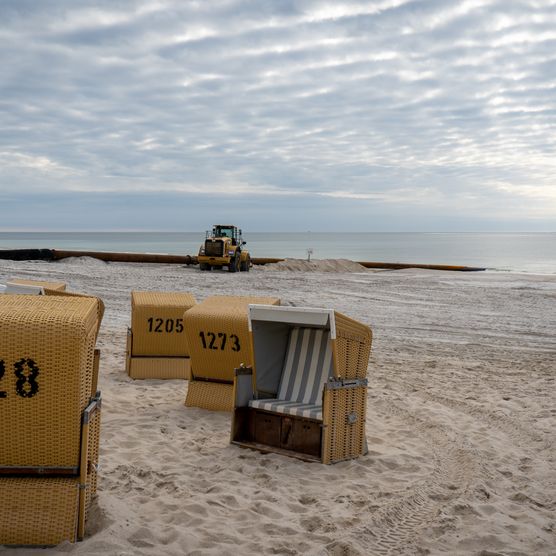 Strandkörbe am Wenningstedter Strand, im Hintergrund fährt ein Bagger