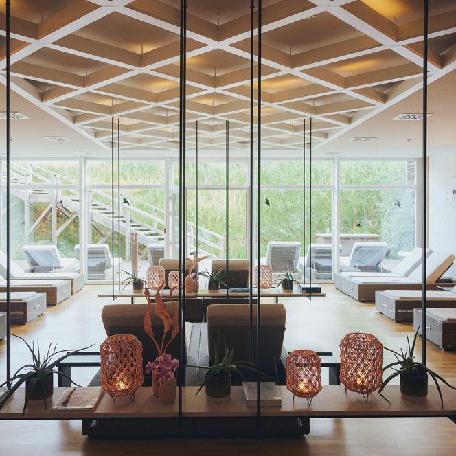 Entspannung pur im Spa des Severin*s Resort & Spa Der Spa-Bereich des Severin*s Resort & Spa in Keitum auf Sylt mit modernen Liegen, geschmackvollen Dekorationen und Blick auf grüne Außenanlagen.