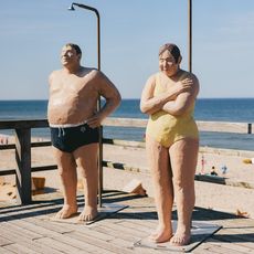 Sculture di un uomo e una donna sotto le docce della spiaggia, note come "Persone comuni" a Wenningstedt sull'isola di Sylt.