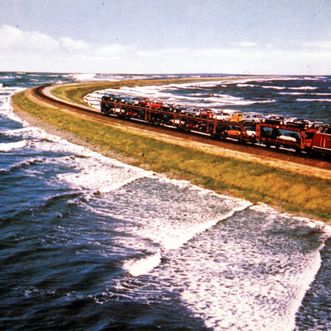 Postkartenmotiv aus den 60er Jahren mit Autozug auf dem Damm