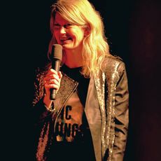 Annika Feldmann spricht lächelnd mit Mikrofon auf einer Bühne.