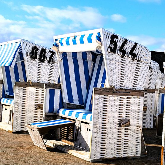 Weiße Strandkörbe mit blau-weißem Streifenmuster auf Sylt