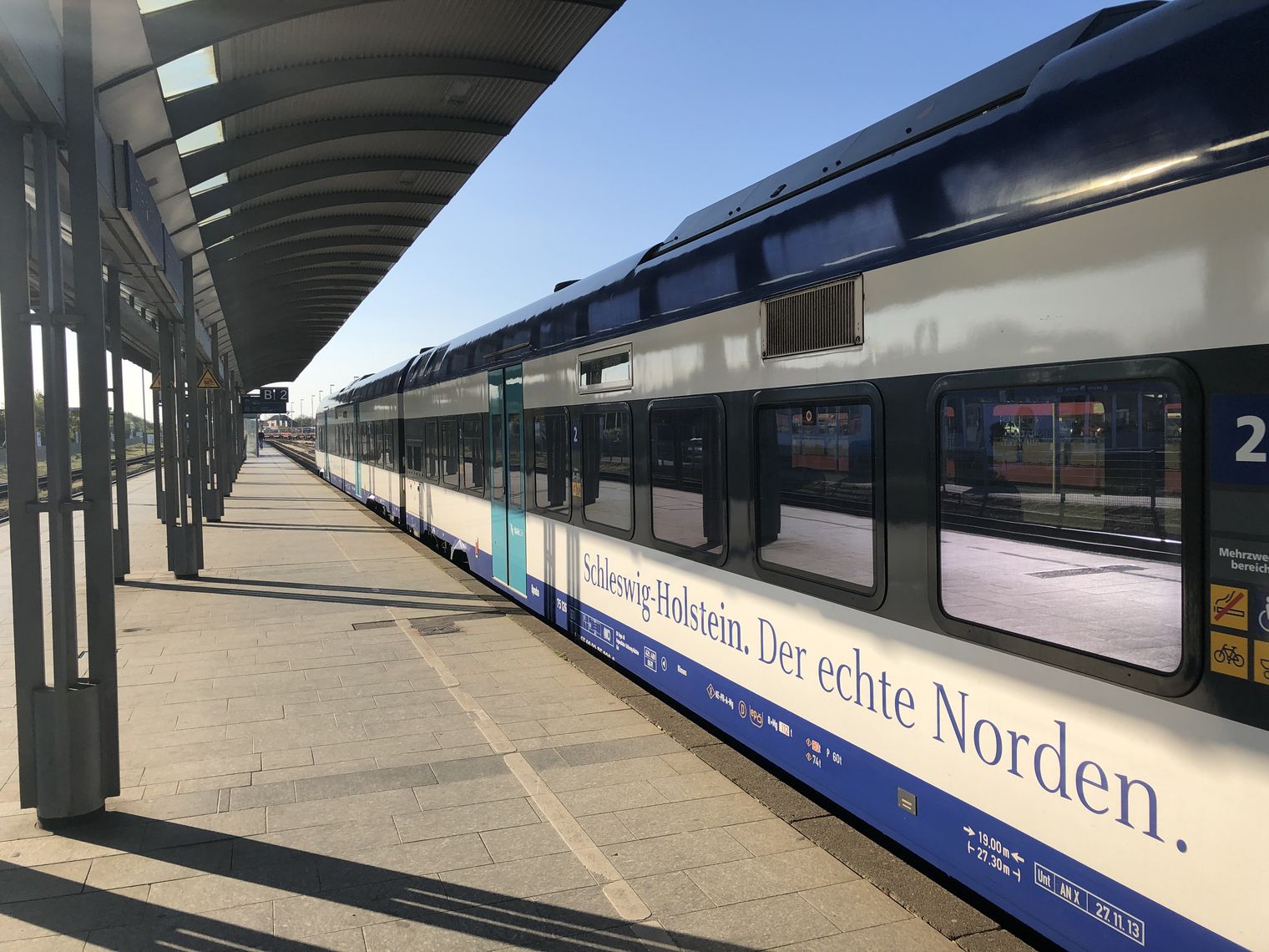 Regionalzug am Bahnsteig in Westerland mit Schriftzug Schleswig-Holstein.