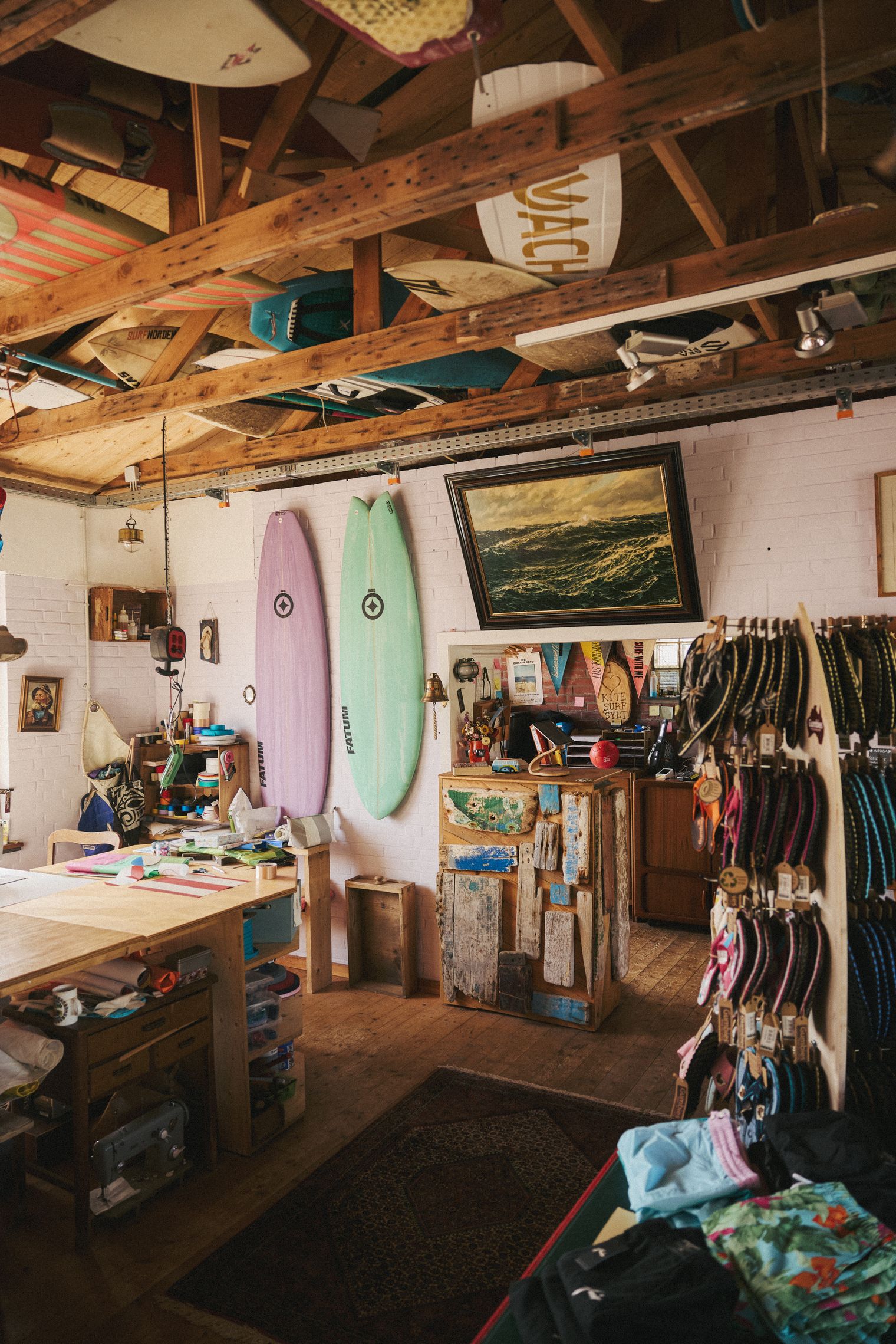 Surfshop mit Surfboards, maritimen Dekorationen und rustikaler Theke. 