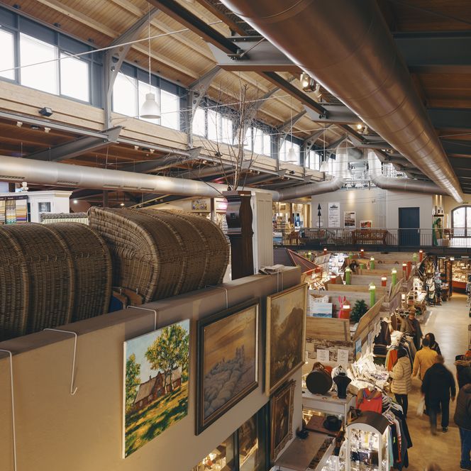 Einkaufsmarkt in alter Halle mit Strandkörben und Kunst