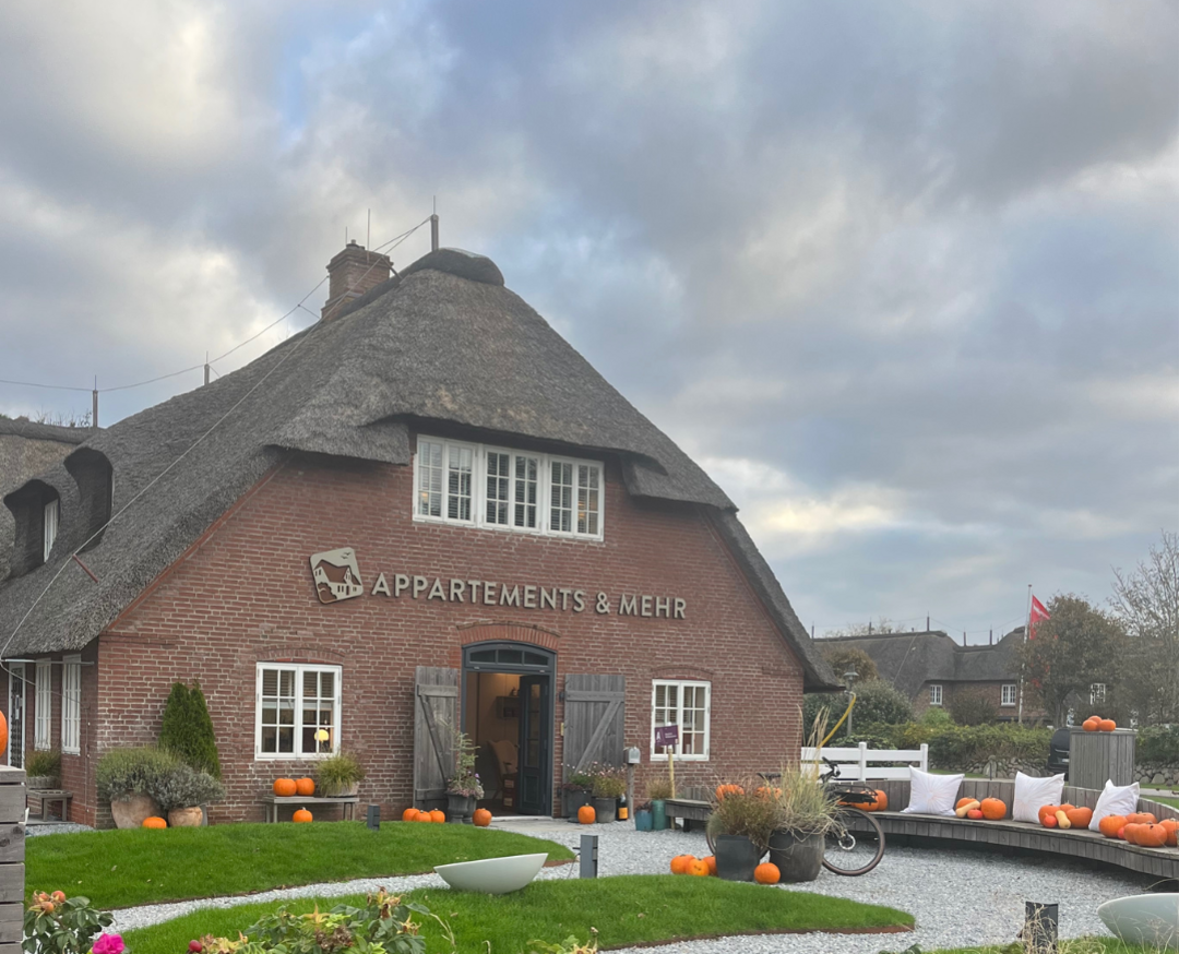 A&M Appartements & Mehr Reetdachhaus mit Kürbisdekoration im Garten in Kampen.