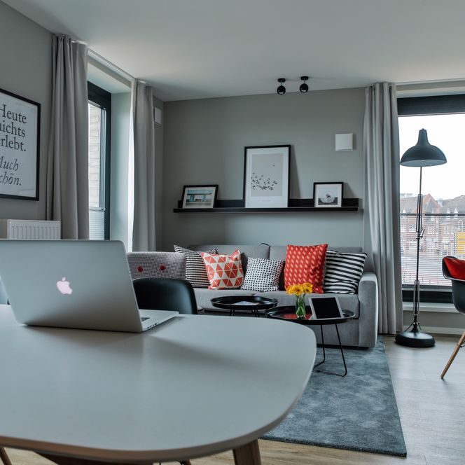 Bett & BudeZimmer 2 Wohnbereich Ein Zimmer, eingerichtet in vorwiegend Grautönen, im Hotel Bett & Bude in Westerland