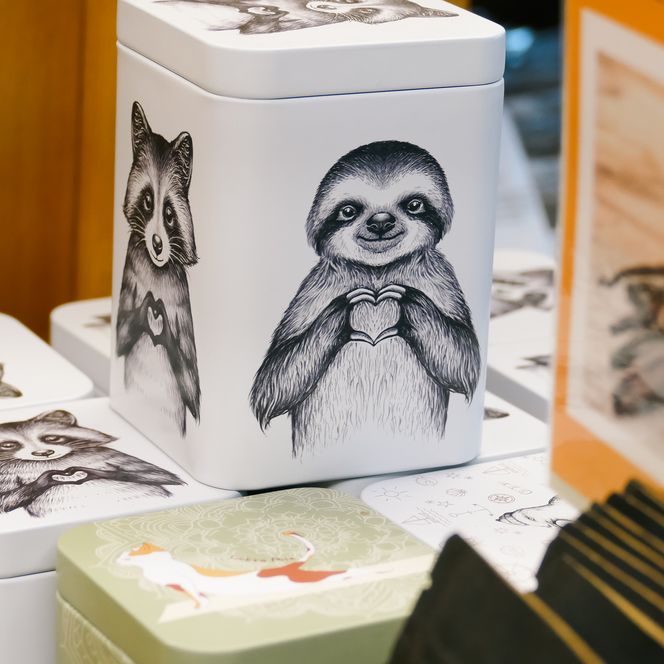Weiße Teedosen mit gezeichneten Tiermotiven stehen zusammen.