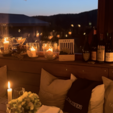 Kerzenbeleuchteter Tisch am Abend mit Blick nach draußen