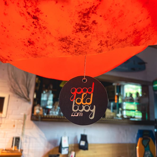Anhänger „good old buoy“ an roter Lampe über der Bar.