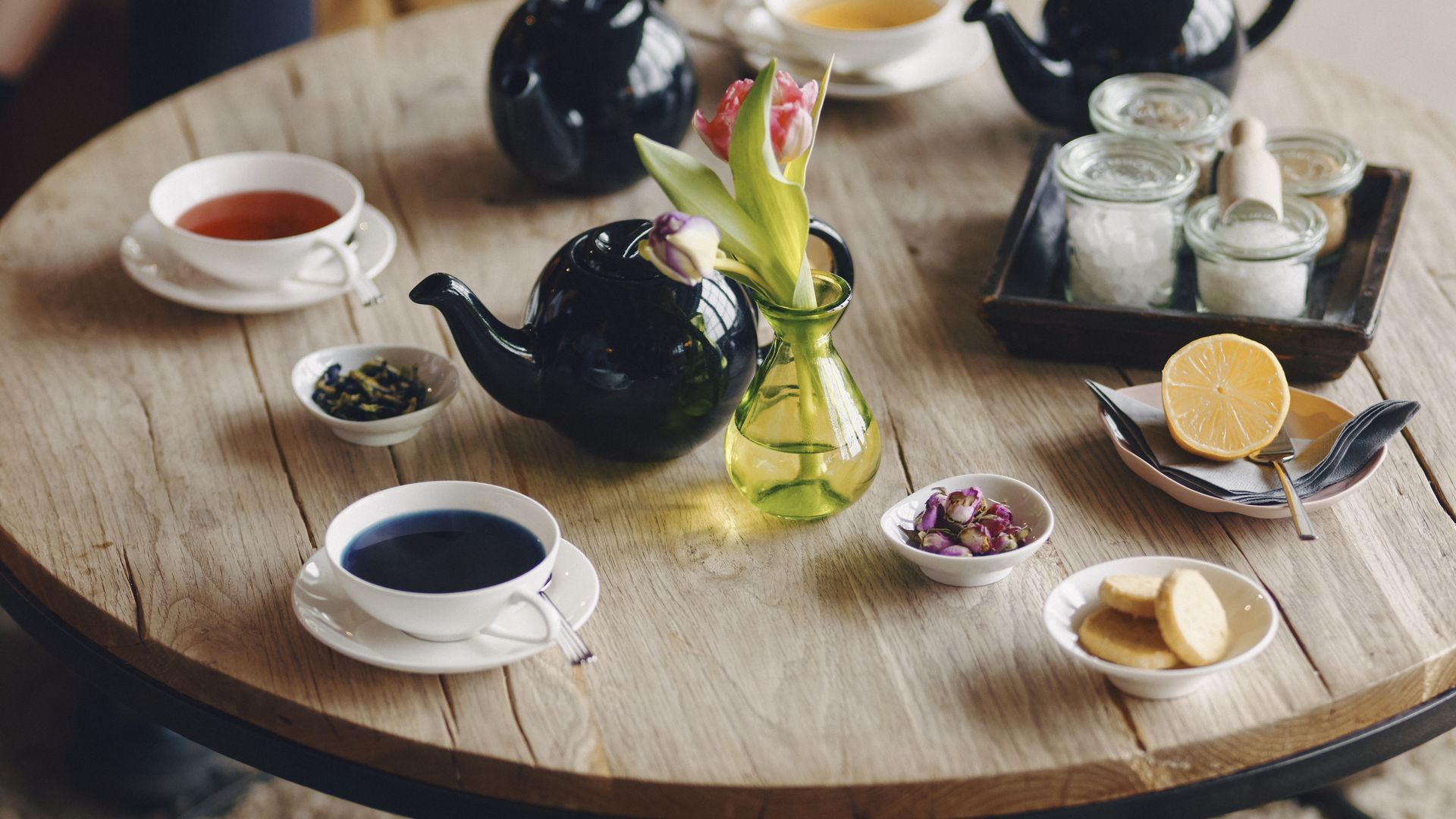 Tisch mit Tee, Gebäck, Blumen und Zeitung auf Sylt