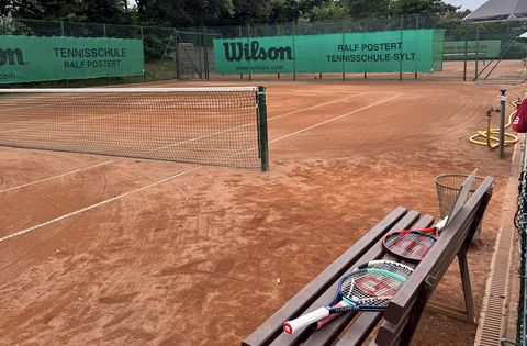Außen-Tennisplatz mit Bank mit Tennisschlägern