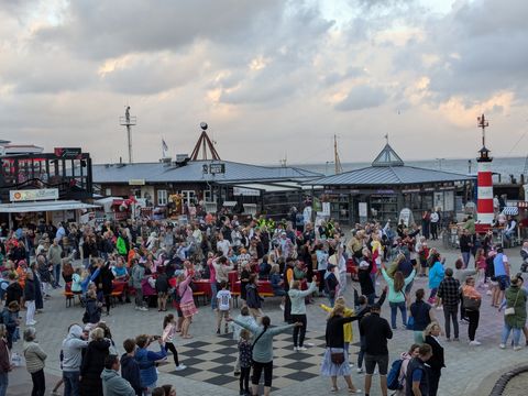 Menschen feiern auf dem Lister Hafenplatz mit Tanz und Musik.