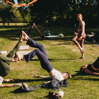 Gruppen machen Partner-Yoga im Freien