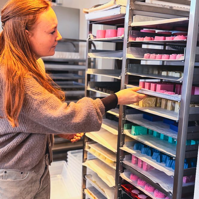 Bunte Seifenboxen mit gestrickten Waschlappen im Korb