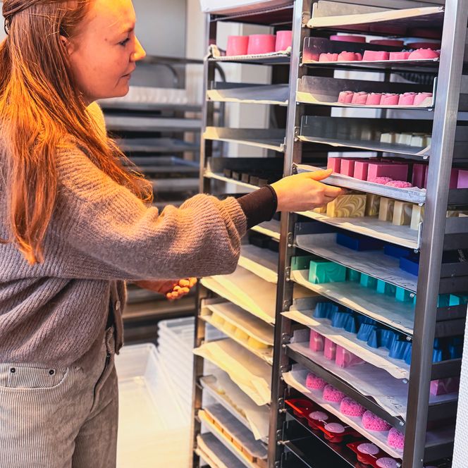 Bunte Seifenboxen mit gestrickten Waschlappen im Korb