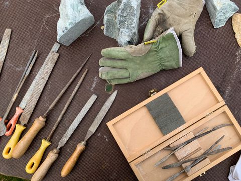 Verschiedene Feilen und Arbeitshandschuhe auf einem Tisch