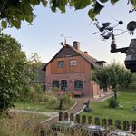 Backsteinhaus mit Garten und Kunstobjekt im Vordergrund in Keitum.