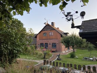 Backsteinhaus mit Garten und Kunstobjekt im Vordergrund in Keitum.