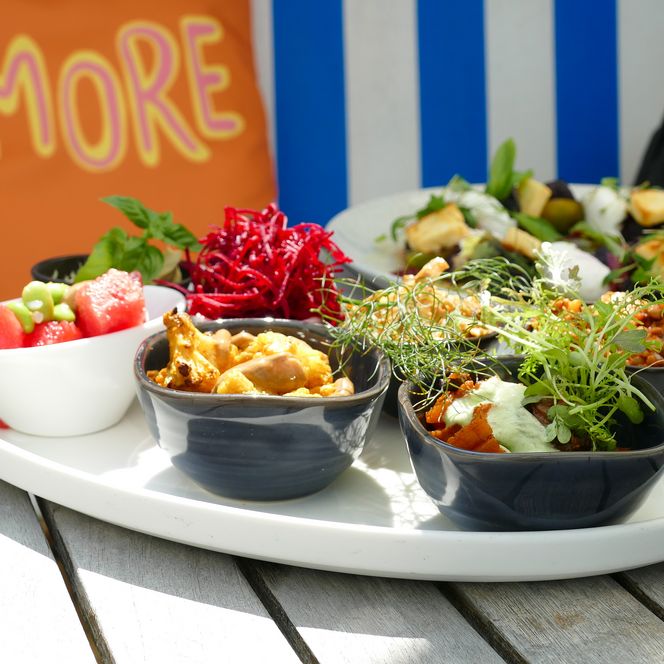 Kleine bunte Schalen mit Gemüse, Salat und Wassermelone auf Platte