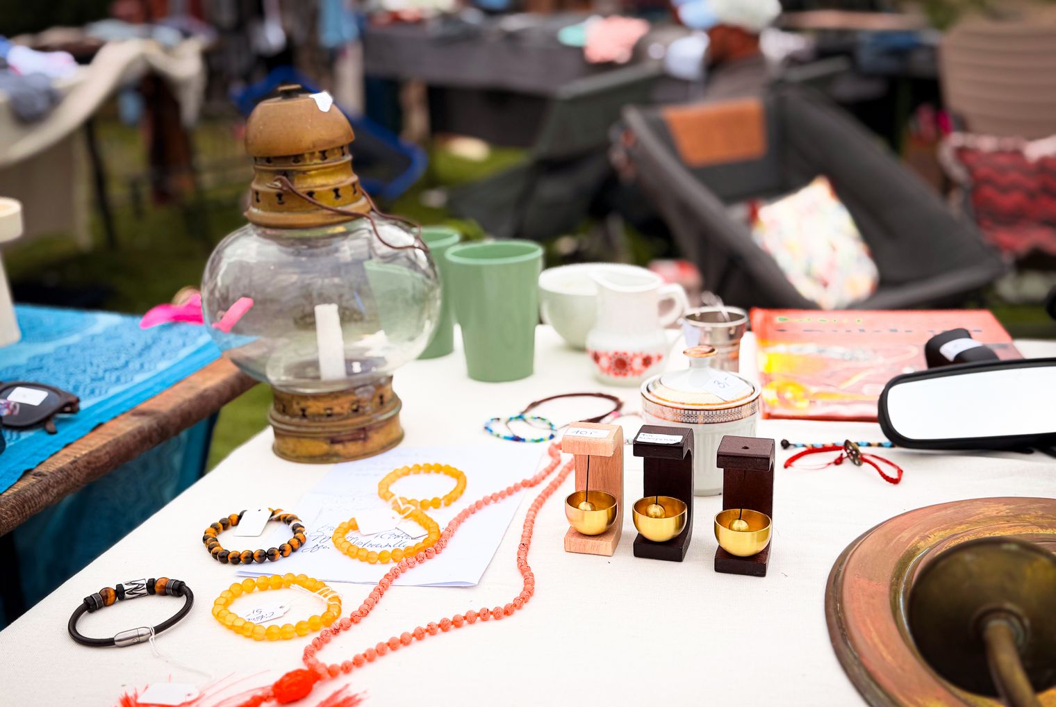 Flohmarktstand mit Schmuck, Geschirr, Messingobjekten und bunten Textilien in Wenningstedt.
