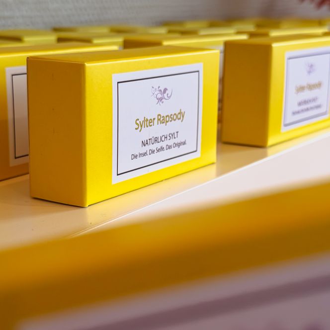 Gelbe Seifenboxen stehen nebeneinander im Regal 