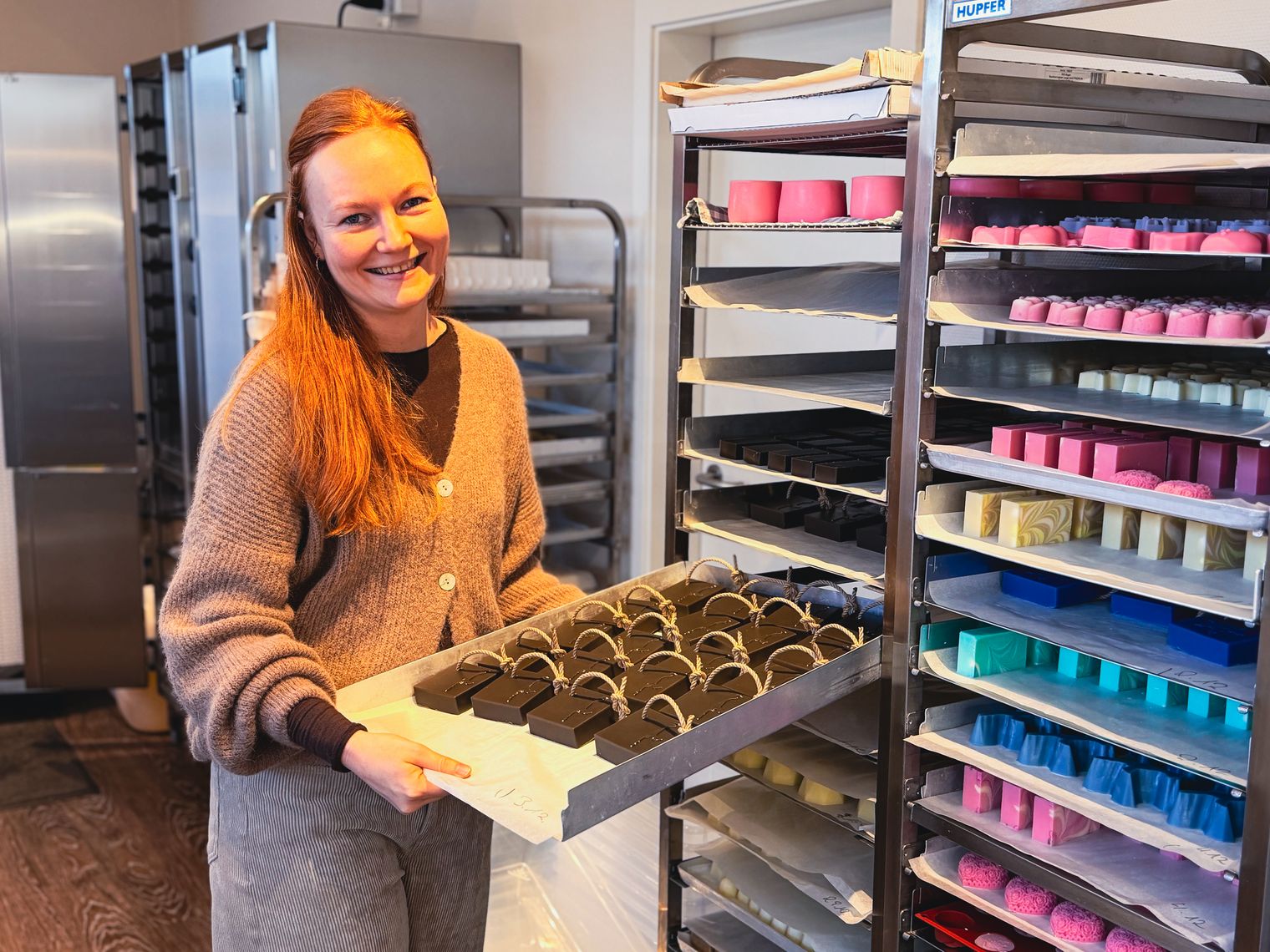 Mitarbeiterin präsentiert Tablett mit handgemachten Seifen