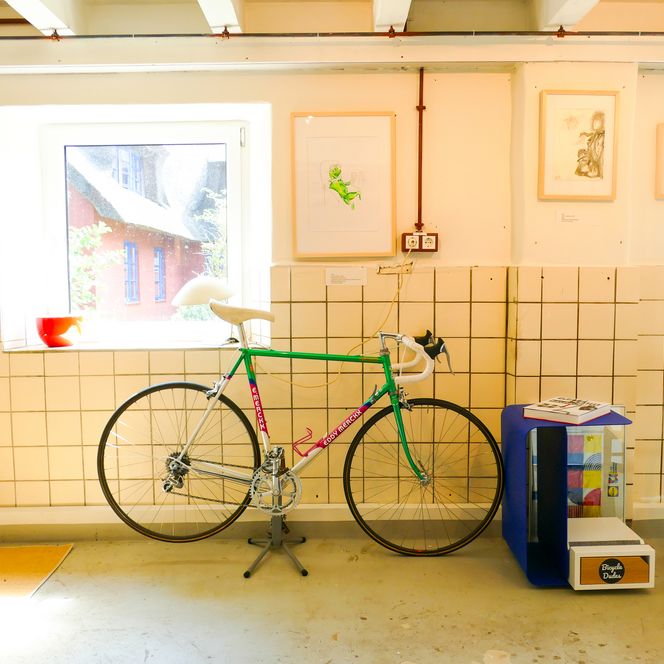 Rennrad vor Fenster in Galerie mit Kunst an den Wänden