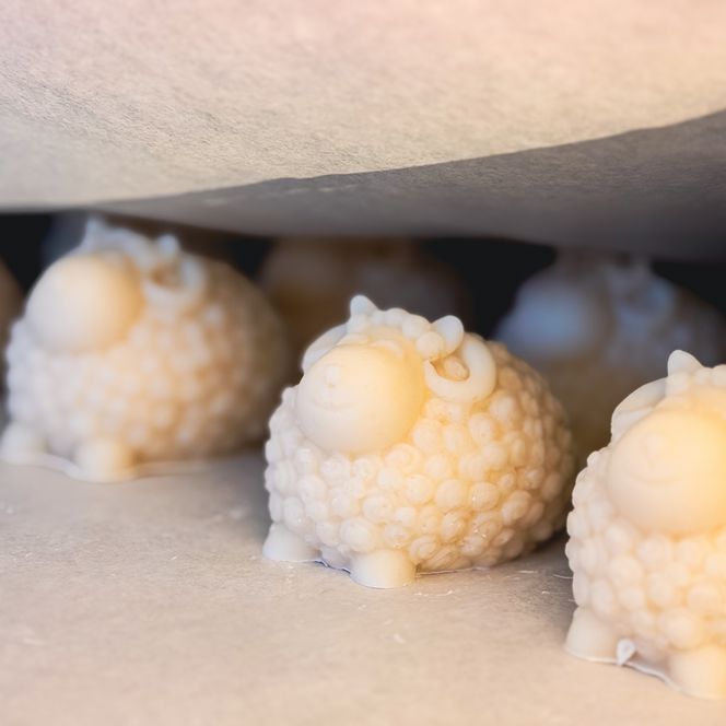 Schafsförmige, cremefarbene Seifen unter Backpapier auf Blech 