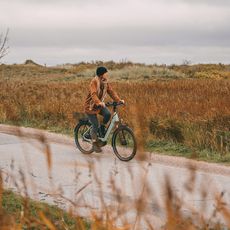 Eine Fahrradfahrerin ist auf einem Radweg in der Sylter Natur unterwegs