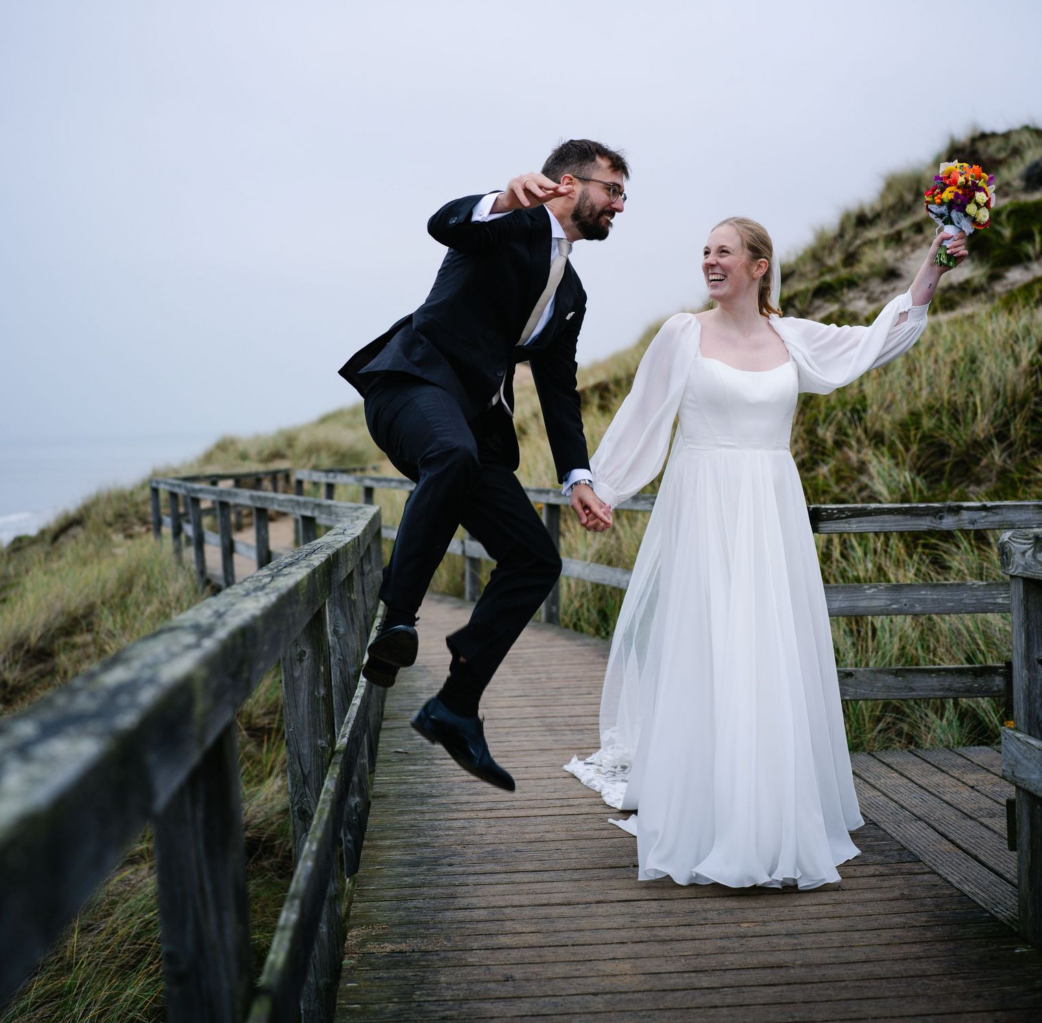 Braut und Bräutigam auf Holzsteg in den Sylter Dünen