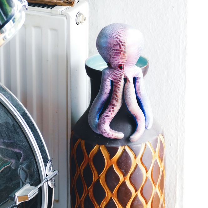 Ein Stofftier-Oktopus sitzt auf einer Vase