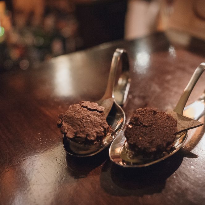 Zwei Löffel mit Schokoladendessert auf dunklem Holztisch